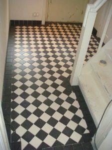 Vloer in de gang betegeld met zwarte band rondom