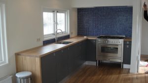 Keuken met houten blad en mozaïek tegels op achterwand